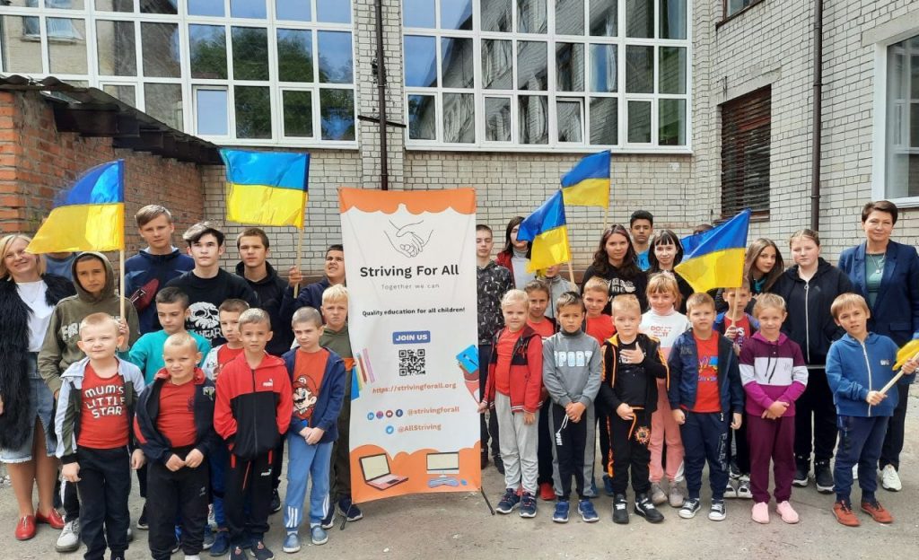 People with Striving For All Banner and Ukrainian flags