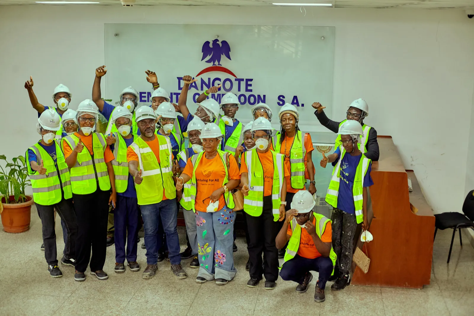 Dangote workers and striving for all workers and students posing with Dangote logo visible