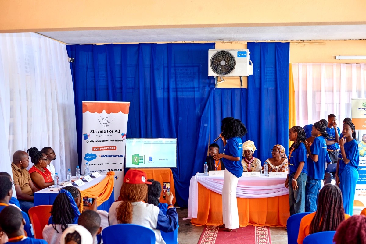 A learner presents a project during the summer closing ceremony as families, educators, and guests look on