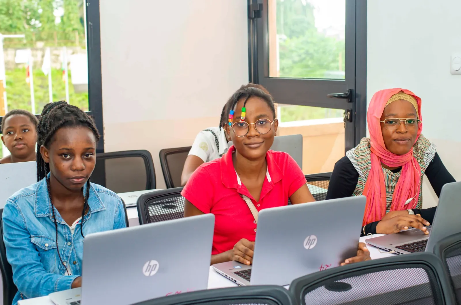 Girls smiling with their laptops infront of them