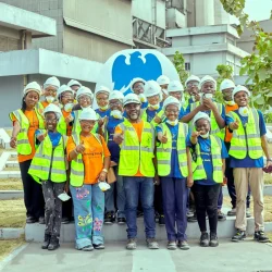 Woker and students posing for a photo in front of Dangote factory